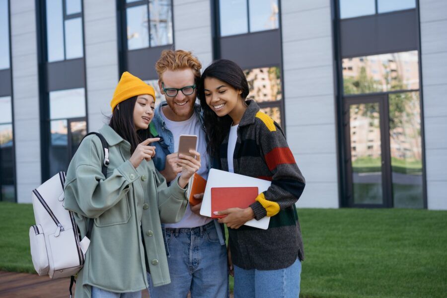 Young friends using phone to look up student loan forgiveness.