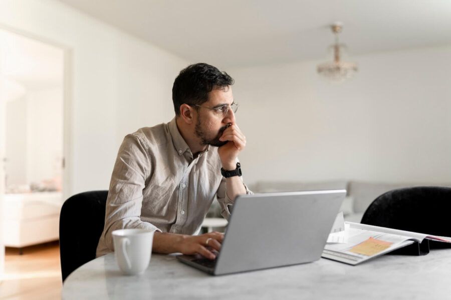 Pensive mature man using his laptop in a home office