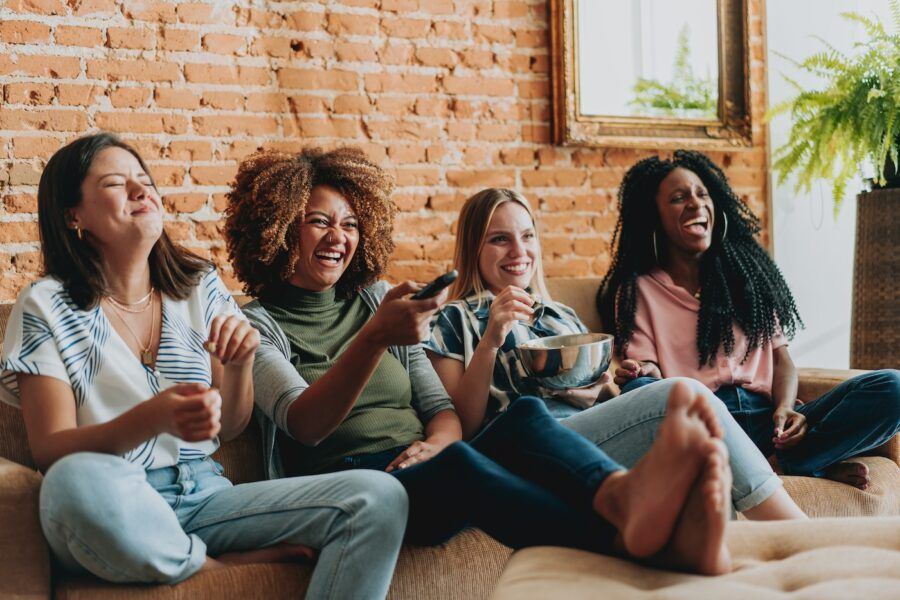 Group of female friends watching tv at home