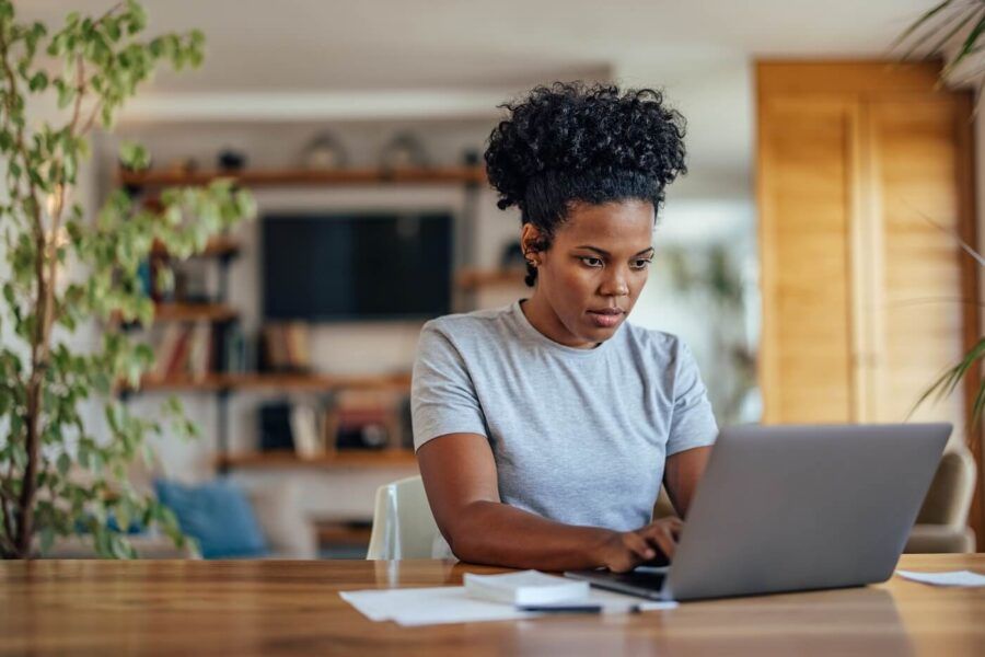 Focused young woman working on her laptop at home