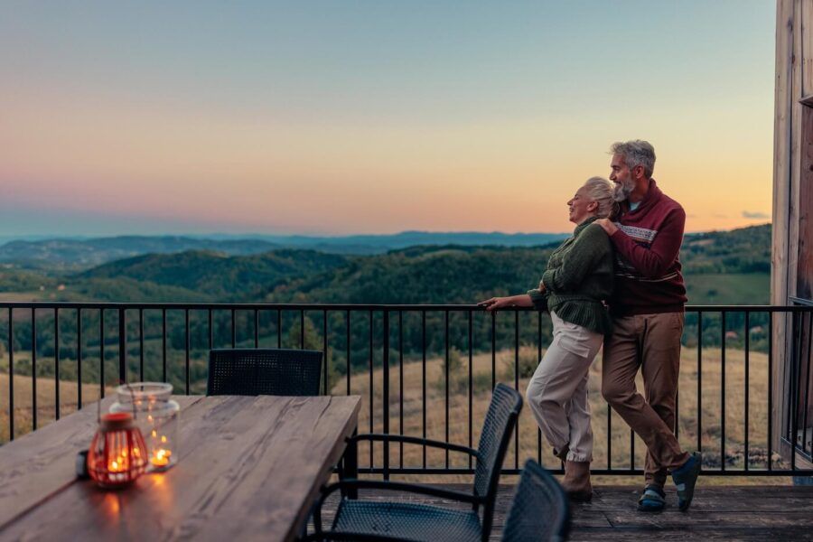 Happy mature couple enjoin sunset on a terrace