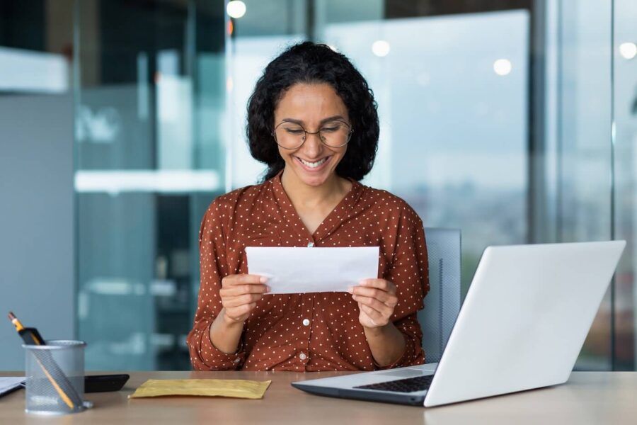 Smiling woman is reviewing the issued check in the office