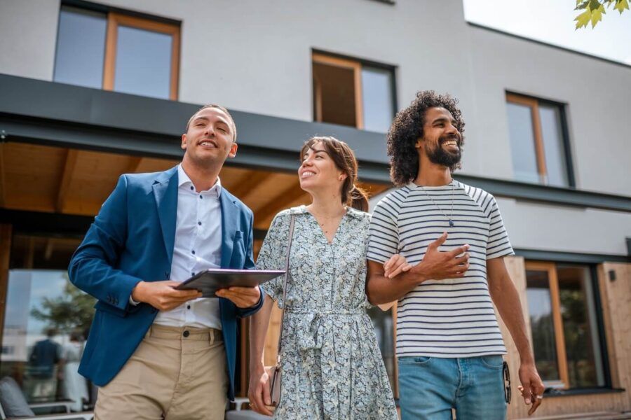 Happy couple viewing the property with a male agent