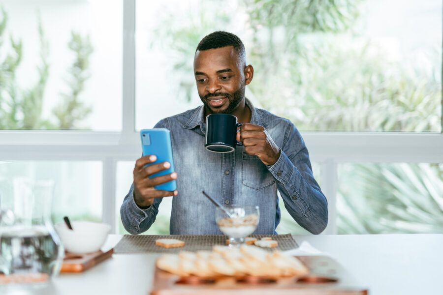 Man using smartphone to research retirement strategies during breakfast