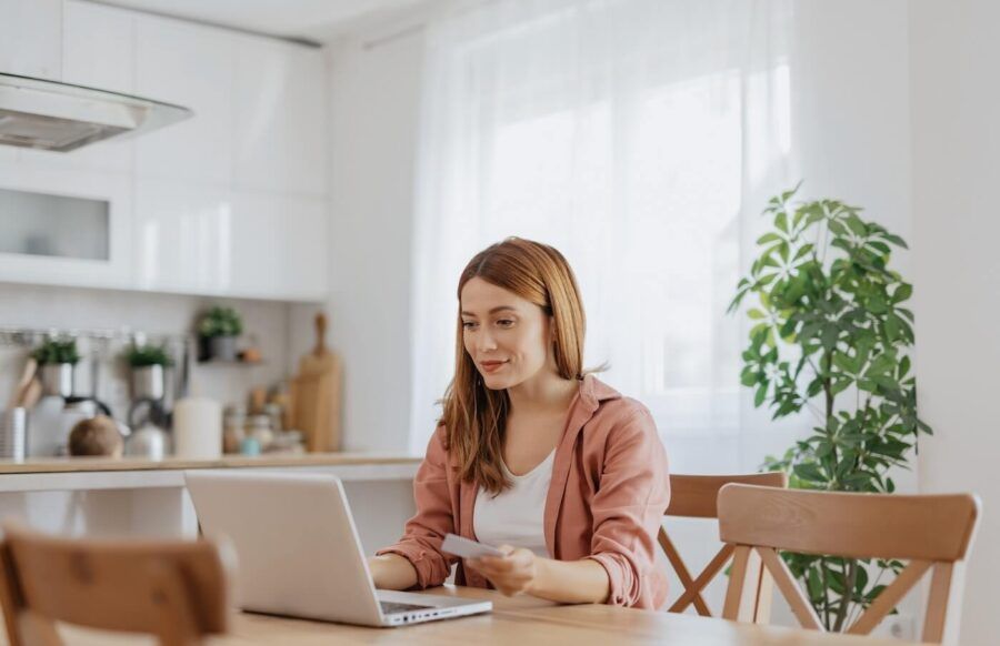 A young woman using her laptop in the kitchen