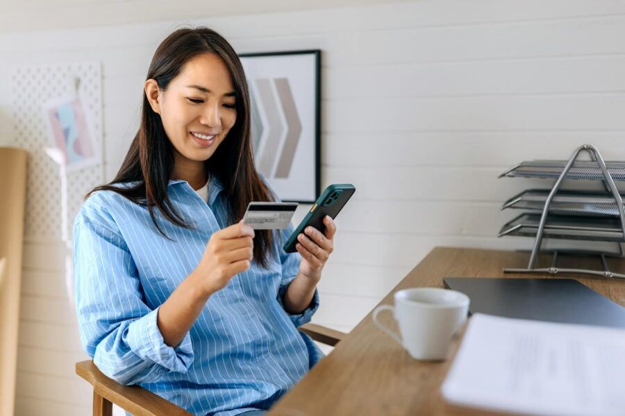 Smiling young woman making a credit card payment in the mobile app