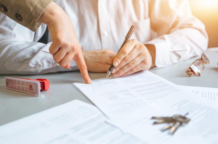 Person signing a certificate deposit agreement with a broker.