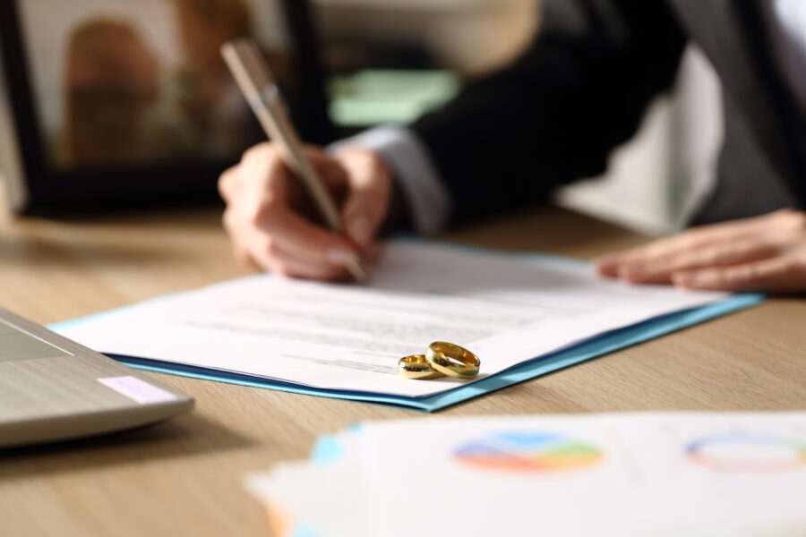 Freelance hands signs refinancing paperwork after divorce