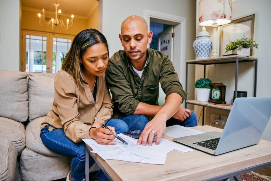 Young couple using laptop and planning their finances at home