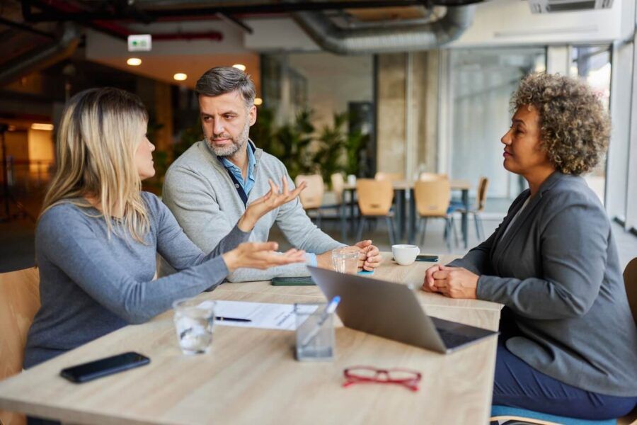Mature couple talking to a female financial adviser
