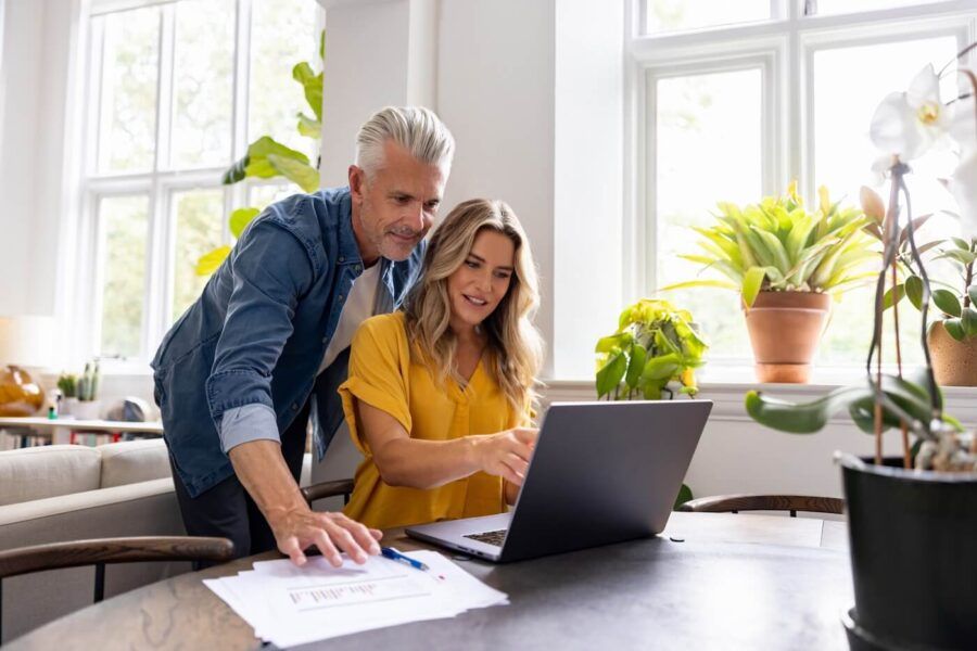 Mature couple looking at the laptop screen while paying their bills