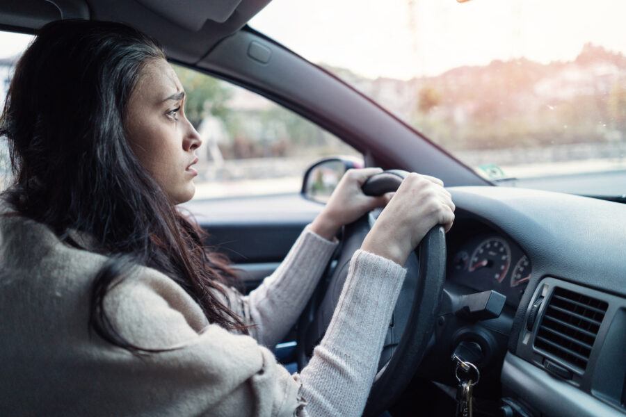 Young female driver looking sad because she was denied a car loan