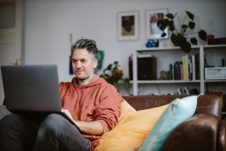 Seated man on couch researching what to do if contributing too much to 401k.