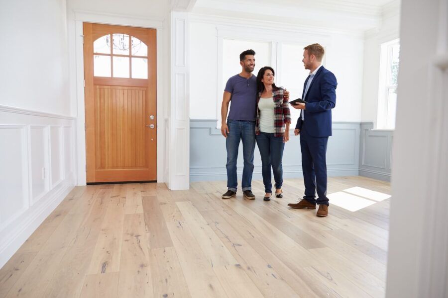 Couple talking to a male real estate agent during open house