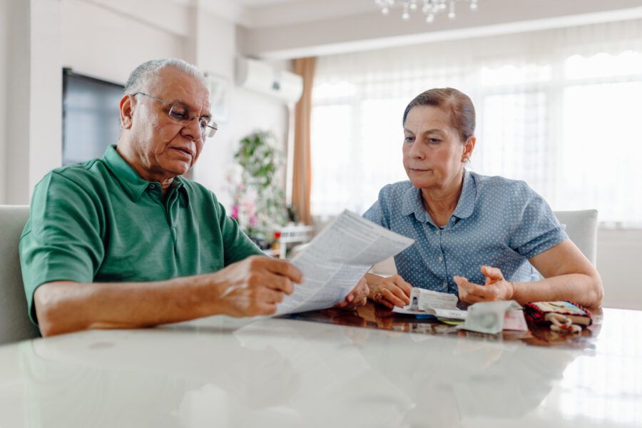 Senior couple at home reviewing their retirement accounts while contemplating bankruptcy.