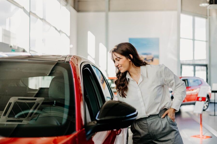 Young woman choosing a new car in a dealership