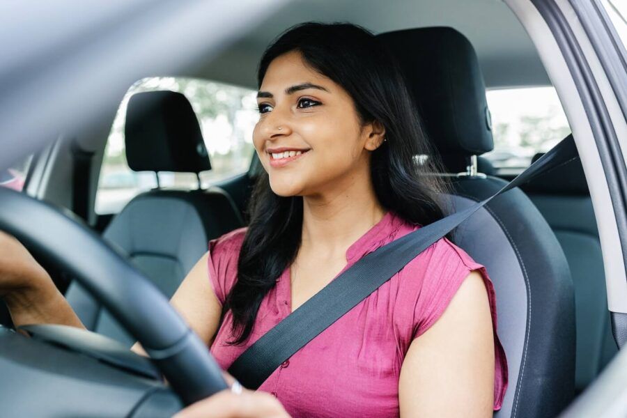 Smiling young woman driving a car
