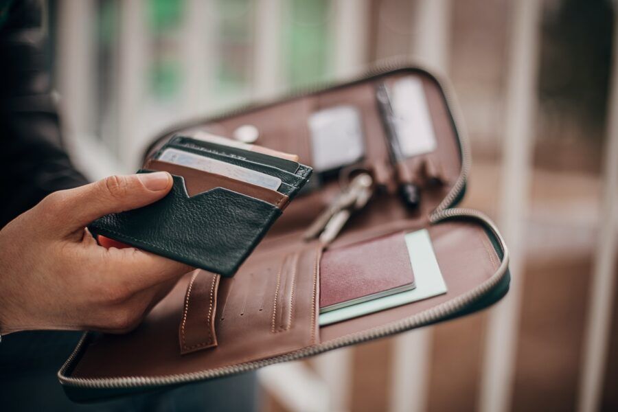 A man holding his leather wallet full of credit cards.