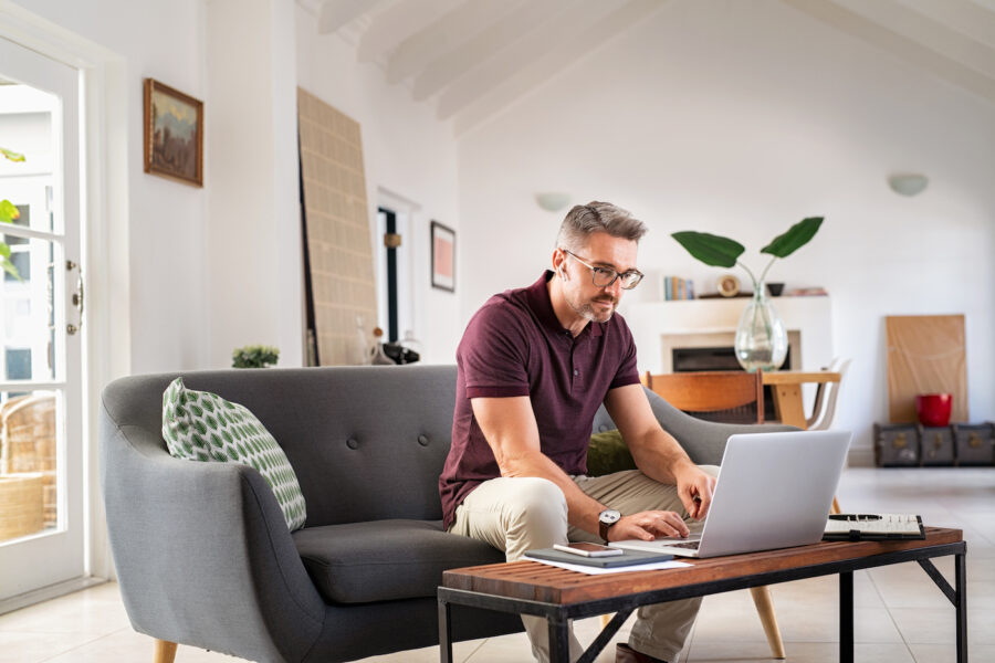 Man working on finances from home on laptop
