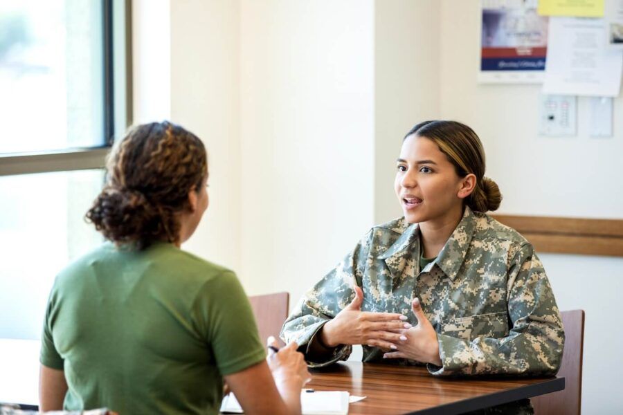 Young military woman talking to a female agent regarding VA loan