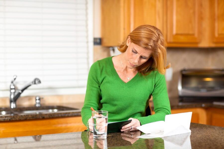 Mature woman voiding a check in the kitchen