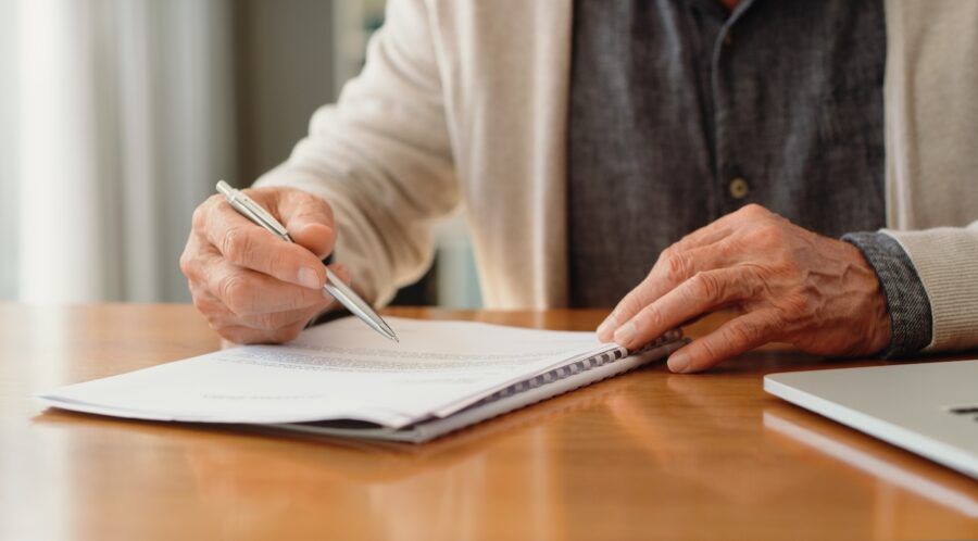 A shot of a man's hands reviewing paperwork about his bank account.