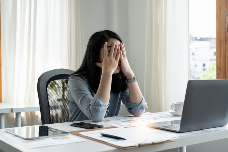 Tired stressed woman working on finances in office.