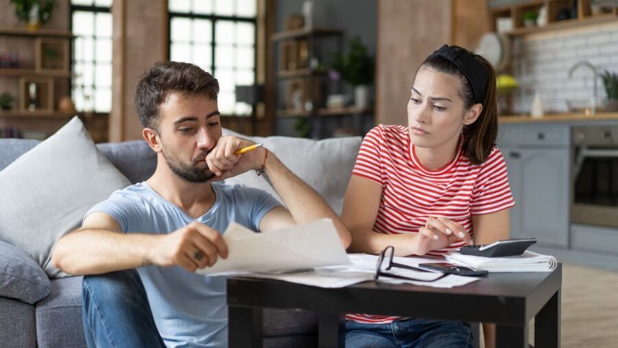 A young couple reviewing their finances at home.