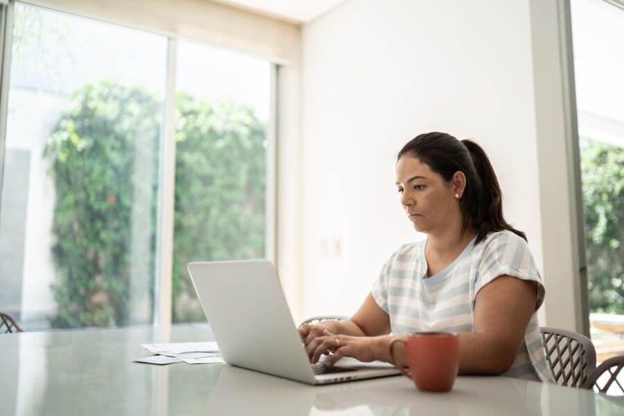 A woman working on taxes on her laptop at home