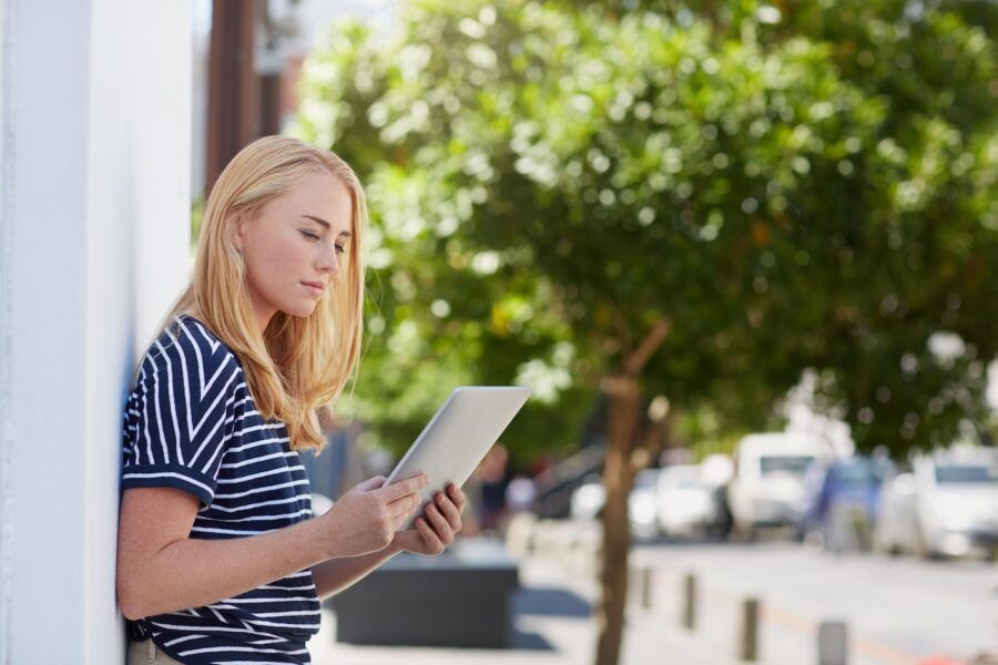 Shot of a young woman using her digital tablet outdoors.