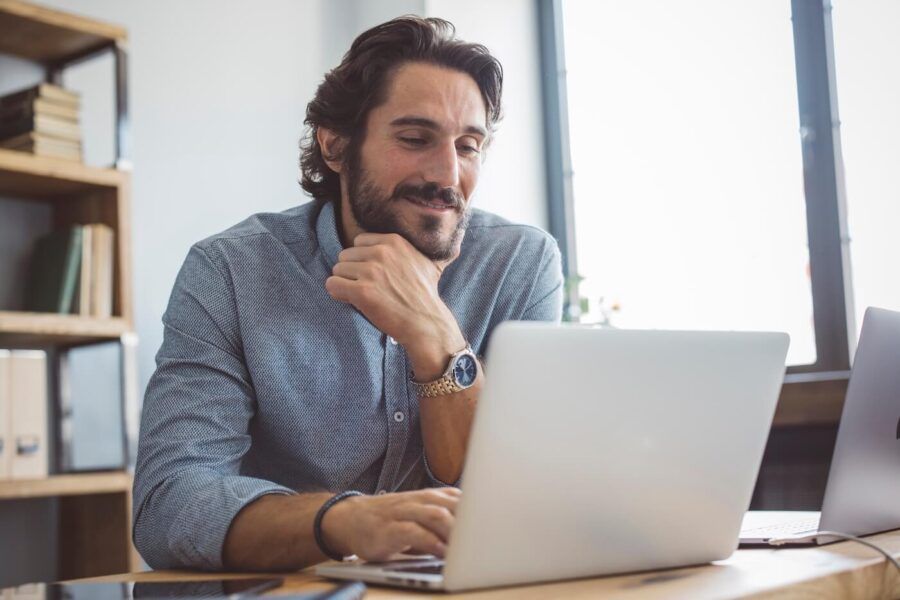 Smiling businessman checking stock market online