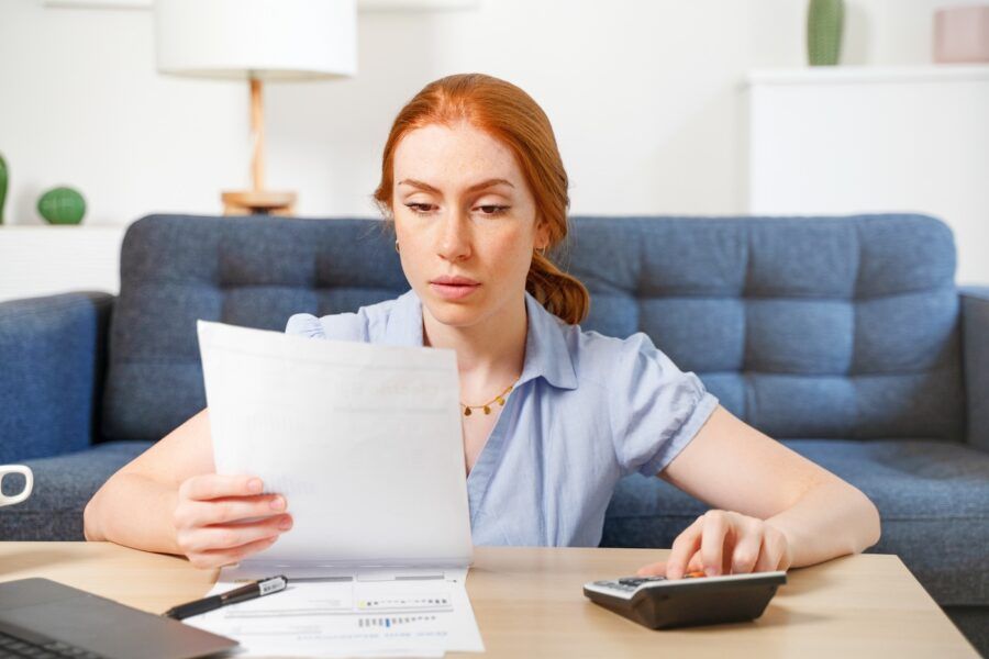 A woman reading her credit report while working at home