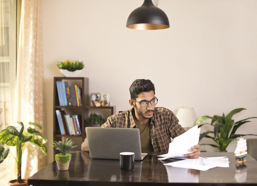 Young man going through paperwork at home office