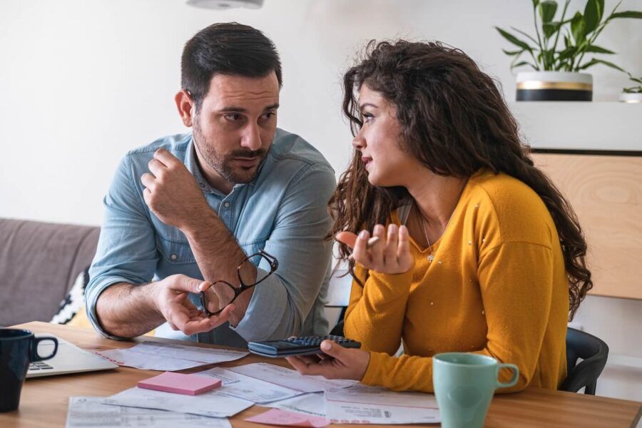 Concerned young couple discussing finances at home