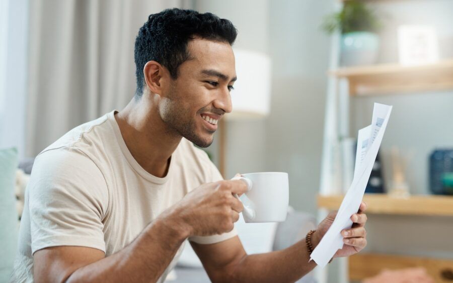 A man with coffee reading financial documents
