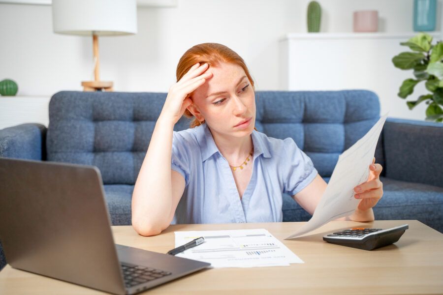 Worried woman working through papers at home