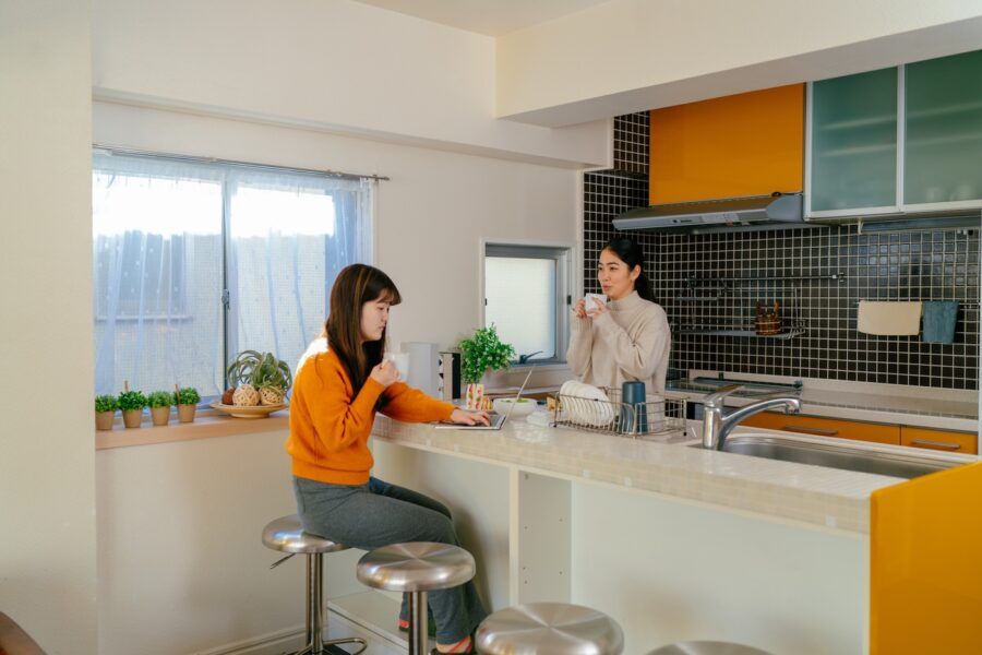 Two young women are having breakfast together in a shared apartment in the morning.