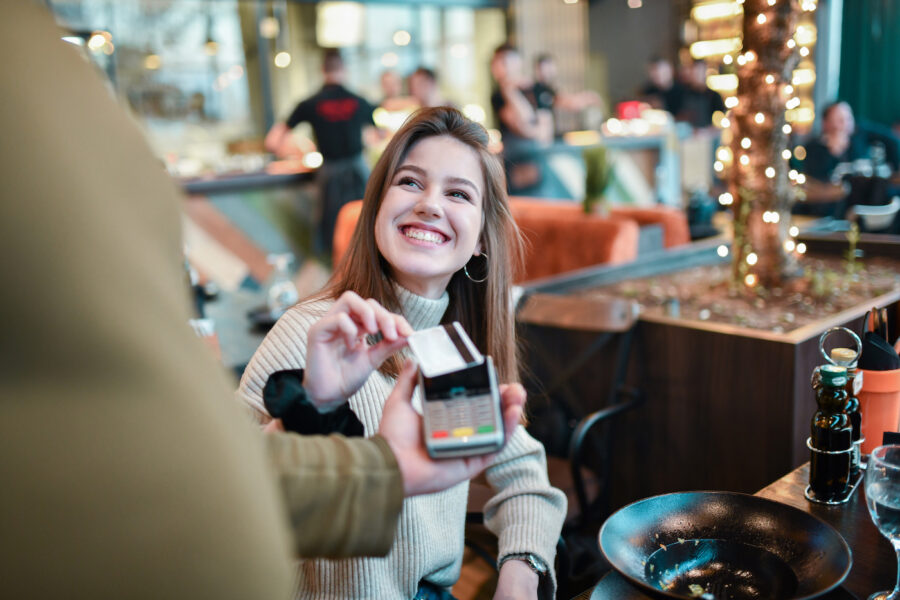 Woman paying with prepaid card in restaurant