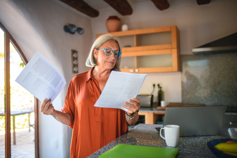 Senior Woman Reading Documents While Working in Kitchen