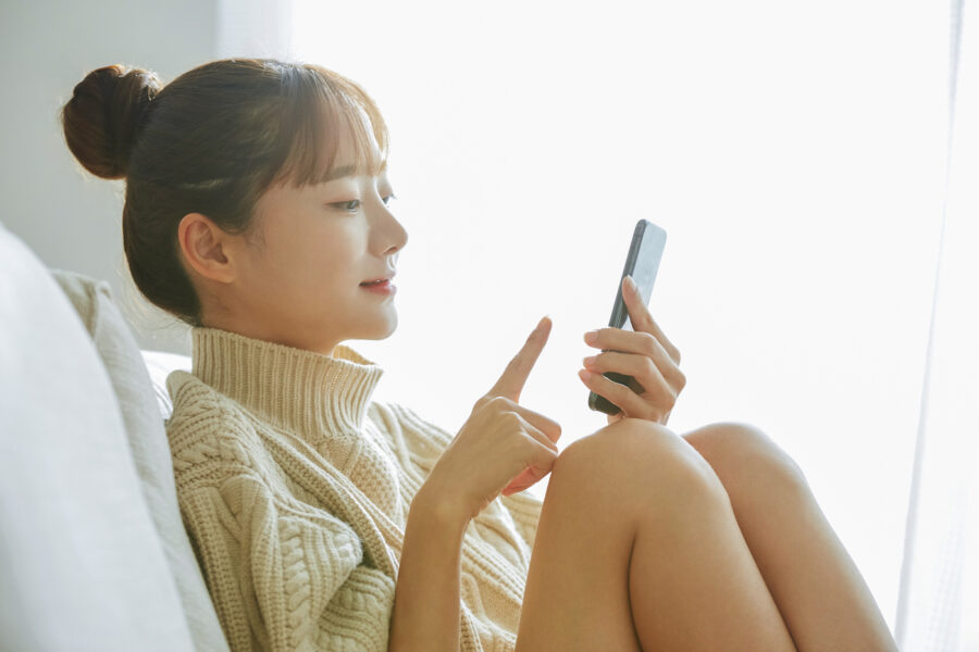 AA woman sitting at home looking at an app on her phone