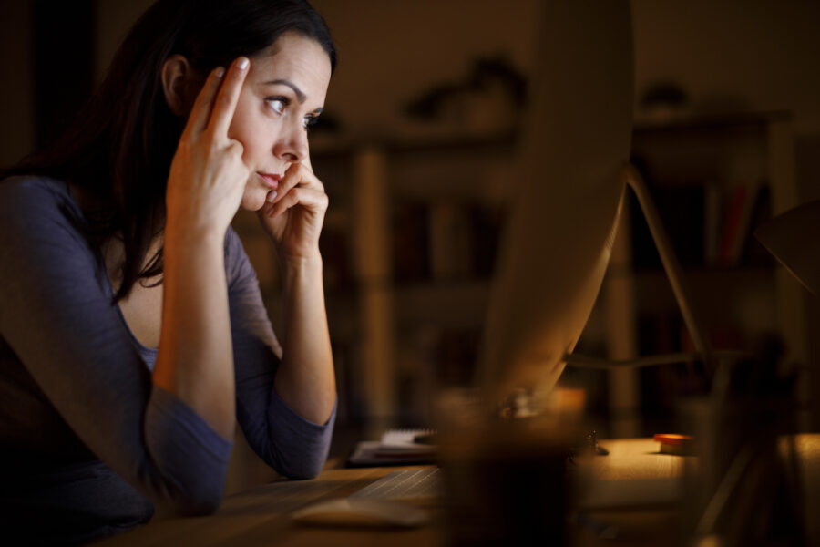 Worried woman looking at computer screen reading about bankruptcy