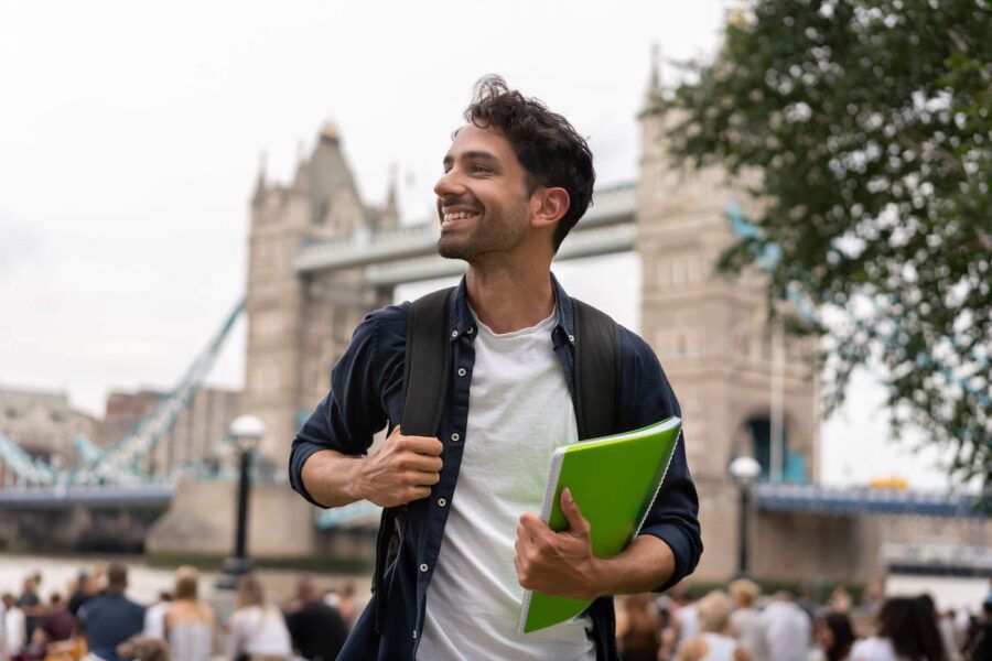 Young smiling male student studying abroad.